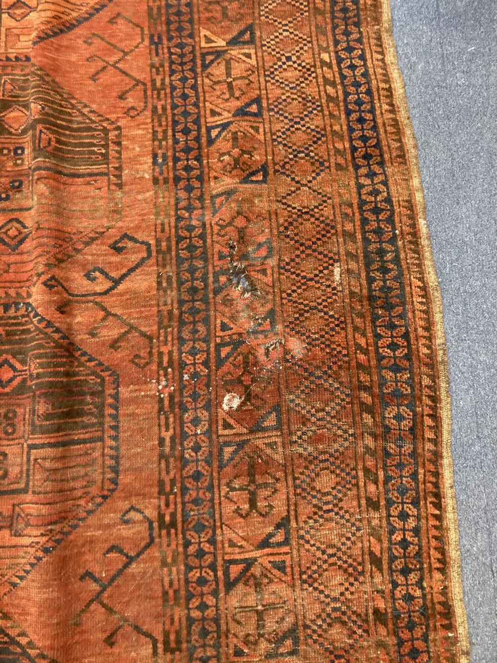 An antique Bokhara burgundy ground carpet, 400 x 280cm